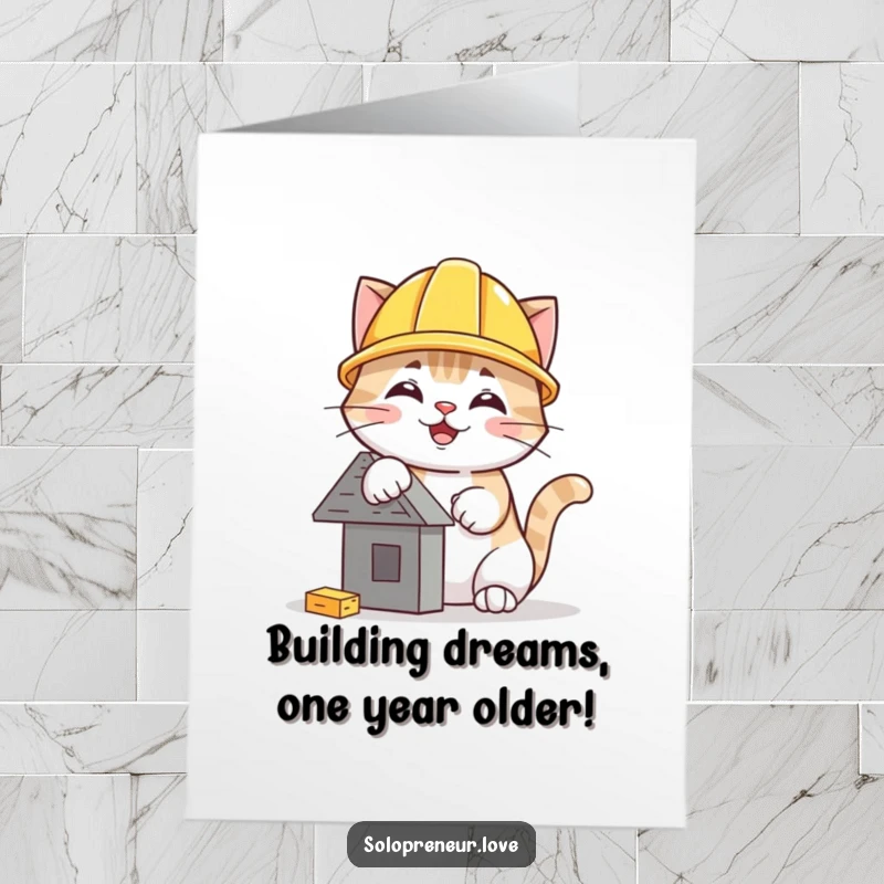Funny Free Printable Birthday Card: A happy cat in a hard hat meticulously building a miniature structure, ready to celebrate.